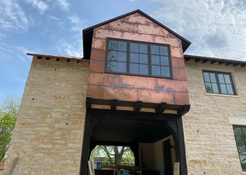 Copper metal panel facade on a stone building for Roof Repair in Bellair-Meadowbrook Terrace